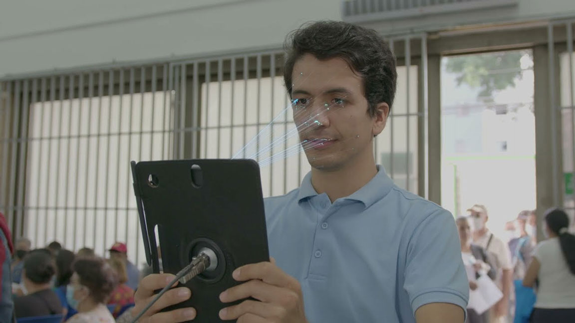 Joven escaneando su rostro enun tablet Audifarma